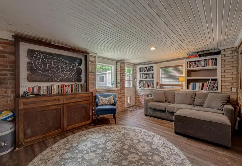 Comfortable lounge area with cozy sofa, bookshelves, and natural light
